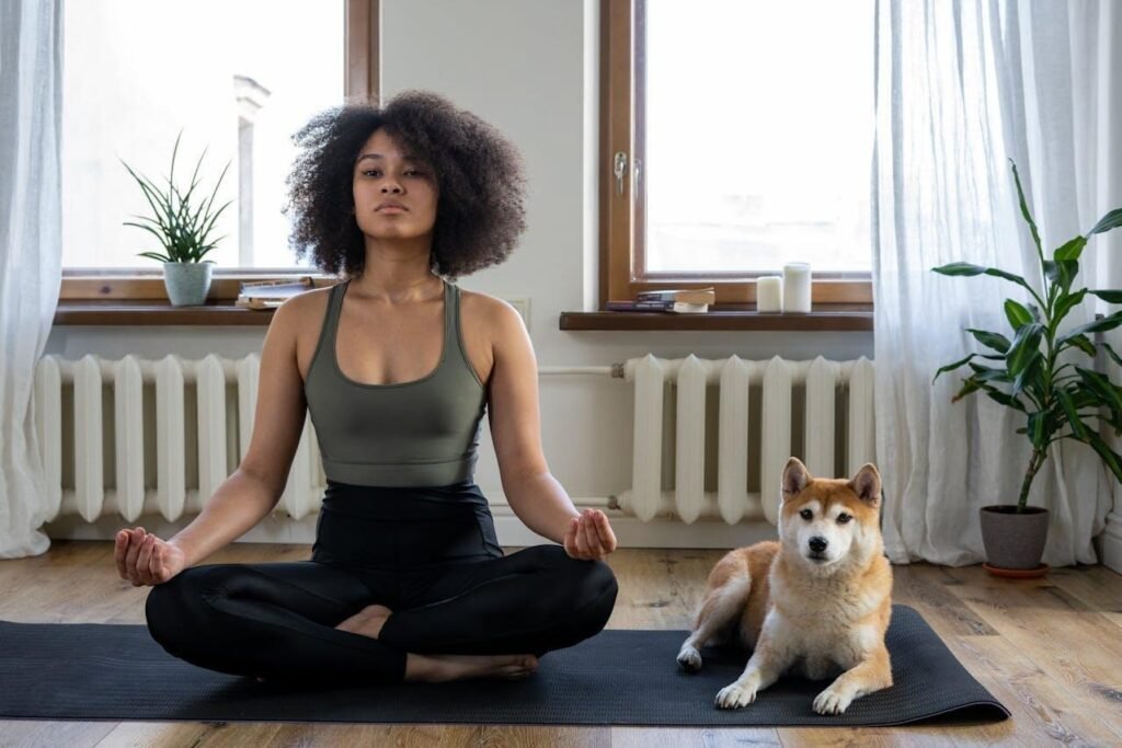 Woman on a yoga mat with her dog